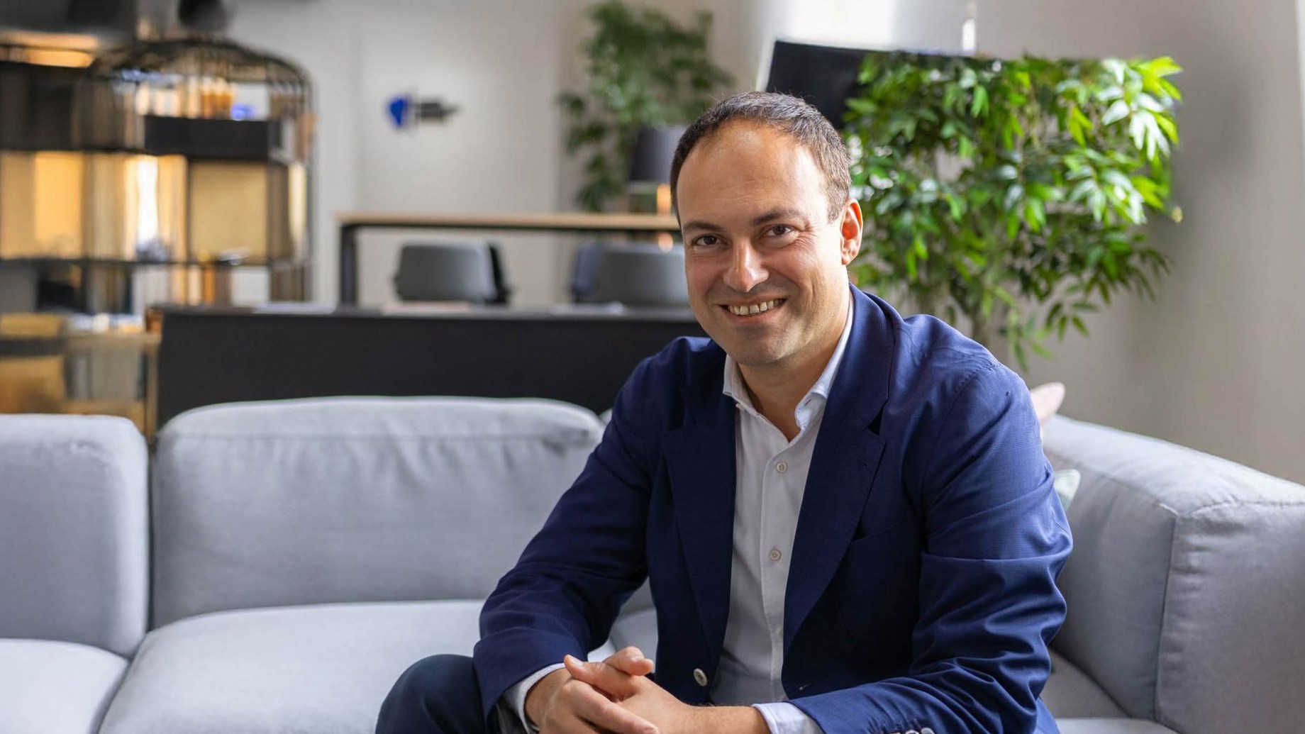 Aaron Etingen, CEO and founder of Global University Systems, sitting in his office and smiling to the camera.