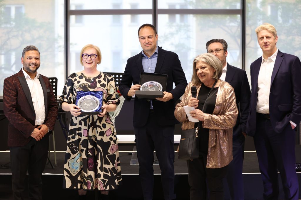 Global University System CEO Aaron Etingen and staff members receiving a prize