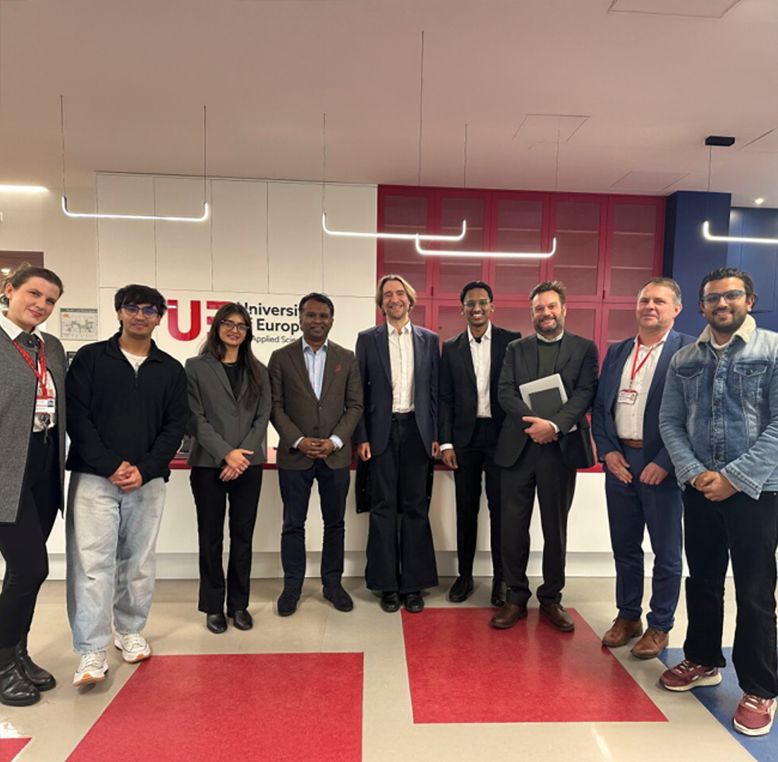 A group of people smiling at UE's campus.