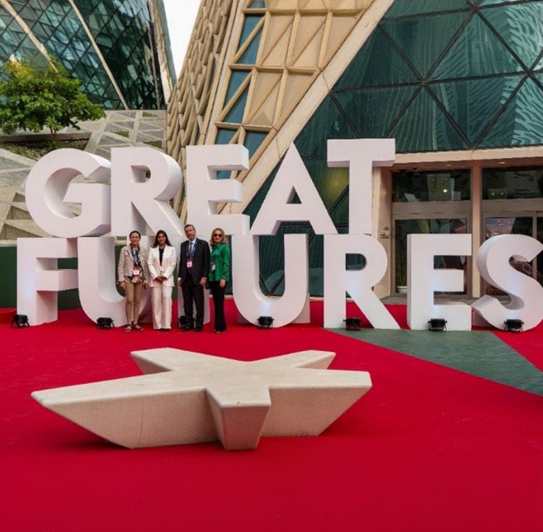 Delegates standing in front of a GREAT FUTURES sign.