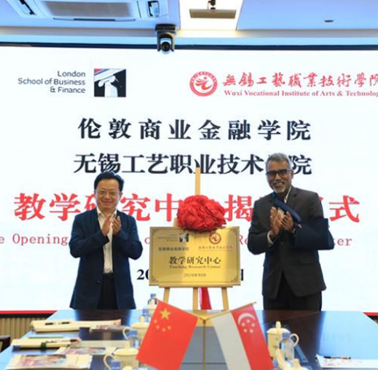 Rathakrishnan Govind, CEO of LSBF Global with delegate of Wuxi standing either side of a plaque