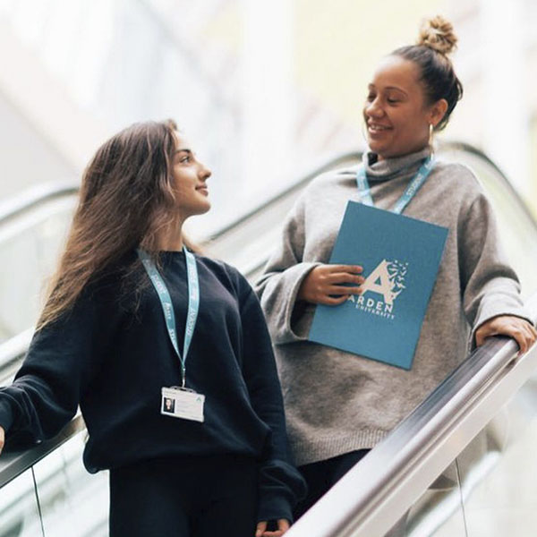 Students talking while going down an escalator