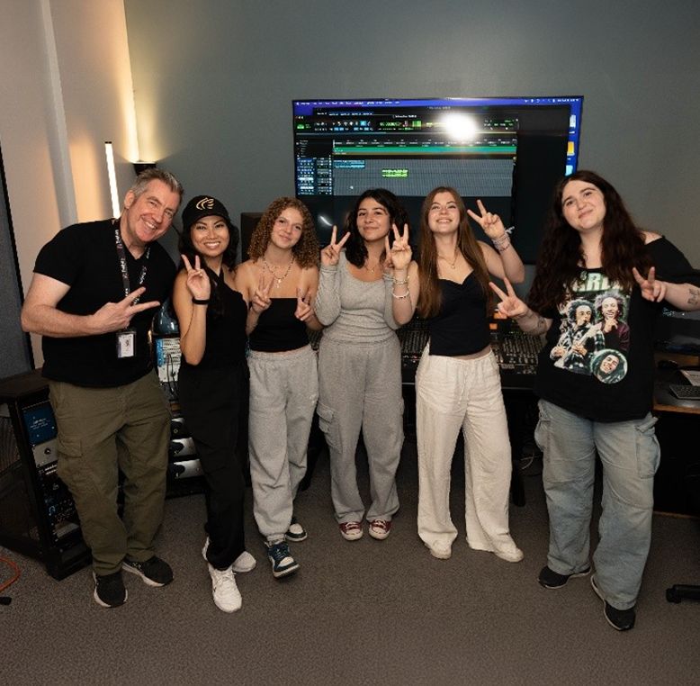 Students from the Resilient Musicians Academy gathered in Trebas Institute Ontario's Sonic Studio, a professional recording studio, after completing their first music recording session in a professional setting.