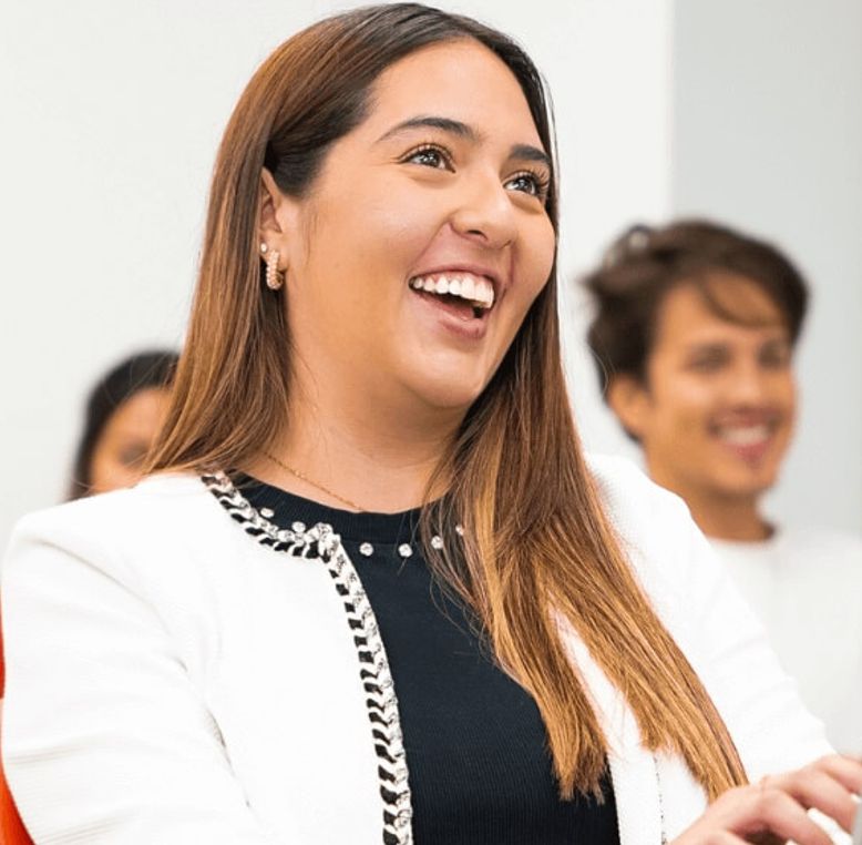Girl in business attire smiling.