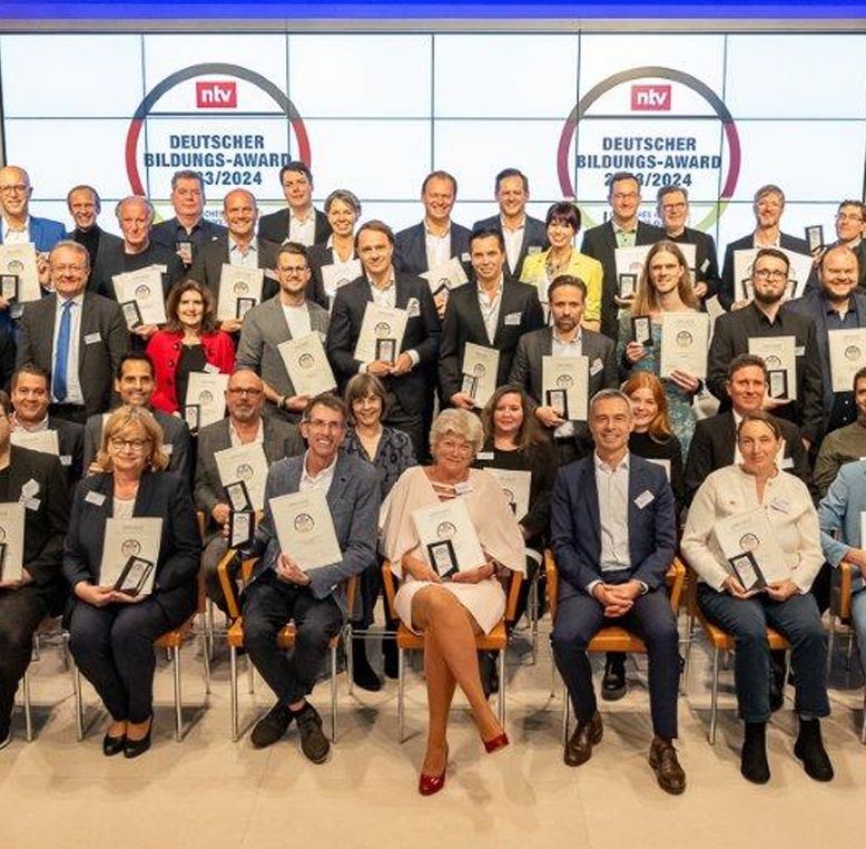 Group photo of award recipients at the Deutscher Bildungs-Award 2023/2024, posing with certificates and awards in front of an ntv backdrop.
