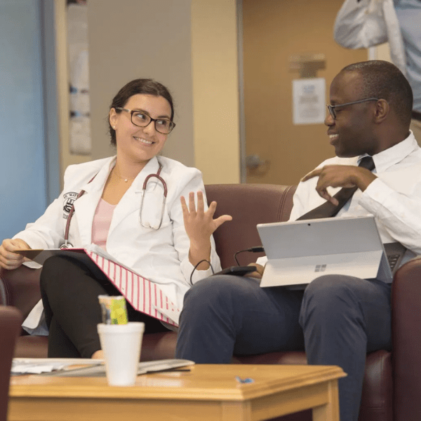 Two medical students sitting on a chair sharing information