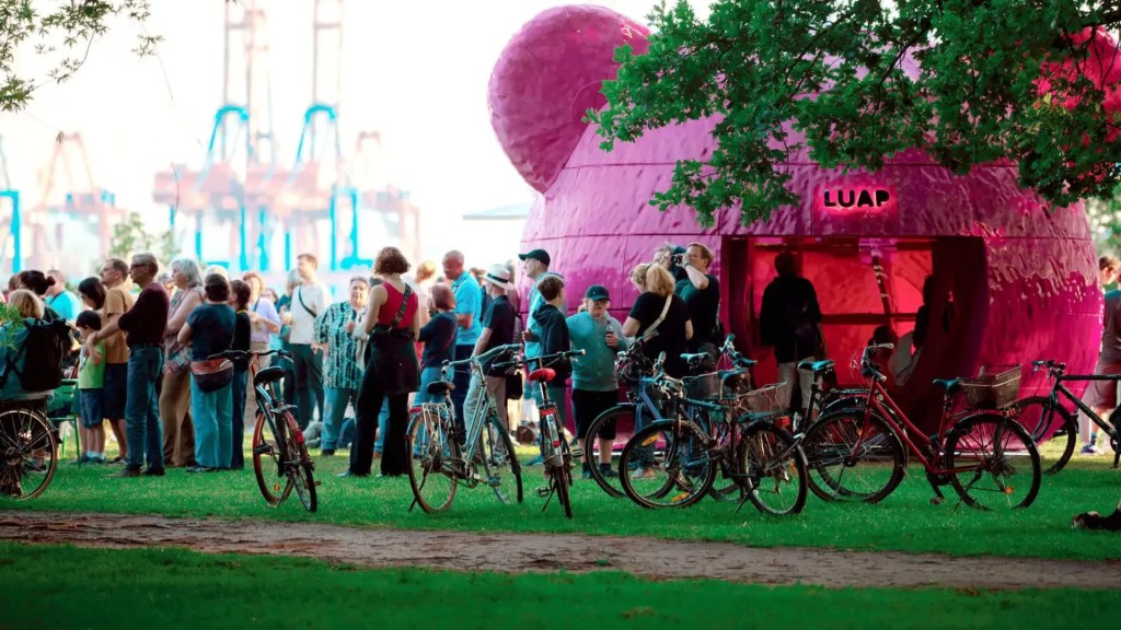 A group of people standing in front of LUAP's Pink Bear exhibition