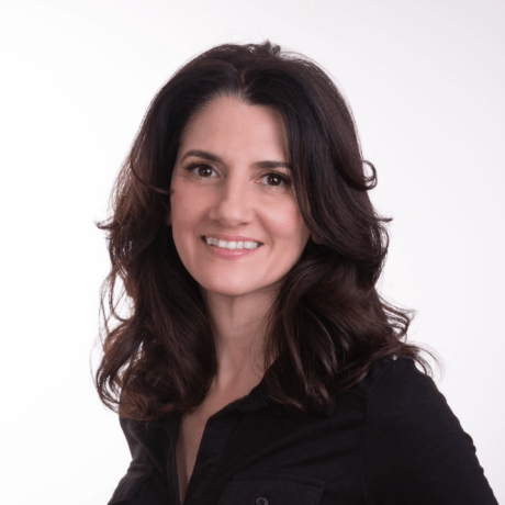 Woman with shoulder-length dark hair wearing a black shirt against a plain light background