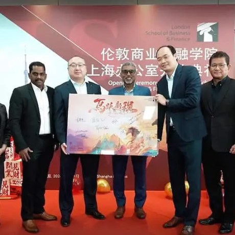 Group photo of representatives at the opening ceremony of the London School of Business and Finance Shanghai office, standing on a red-carpet stage with branded signage and celebratory decorations.