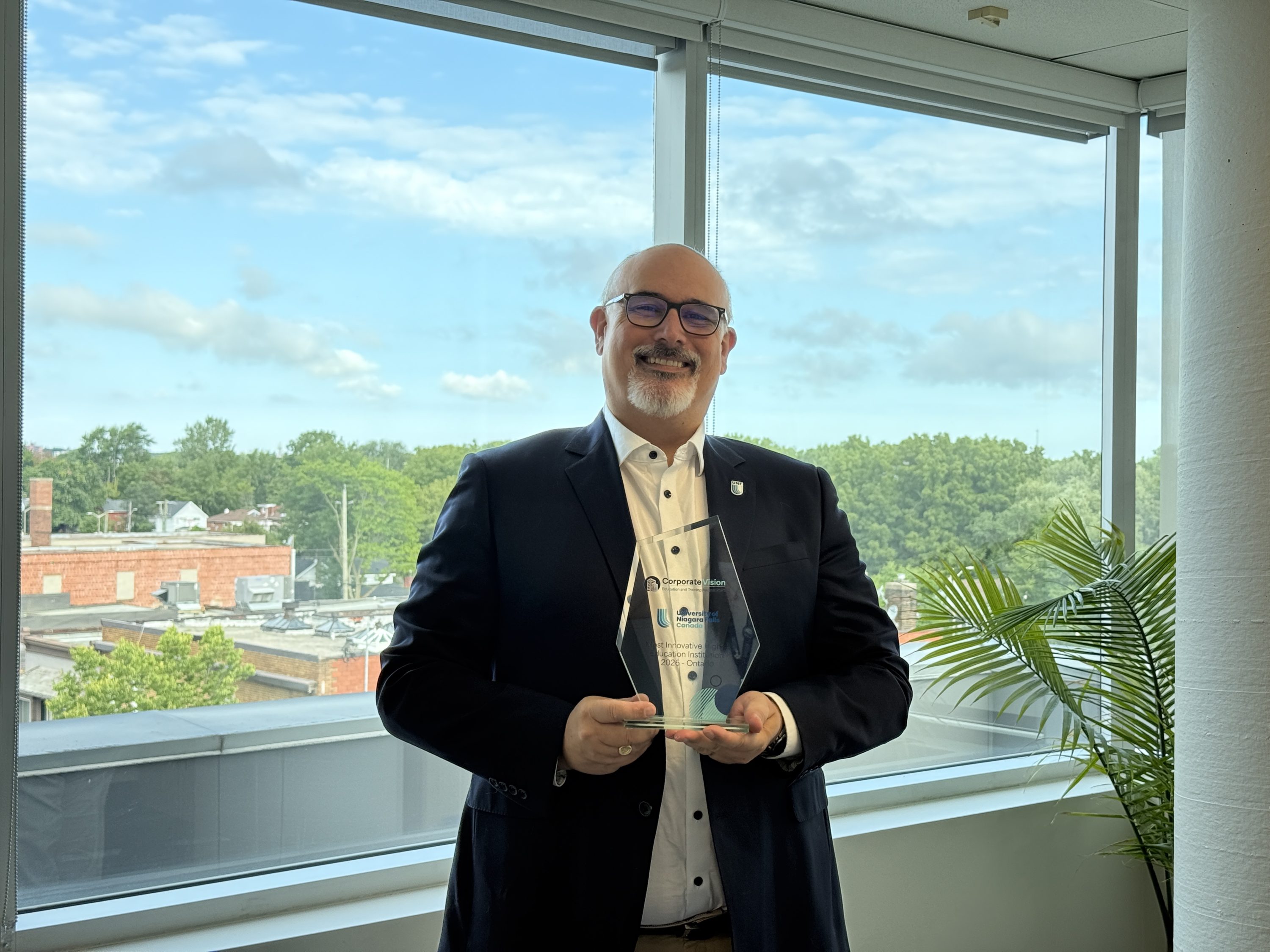 University of Niagara Falls Canada representative holding a Corporate Vision award.